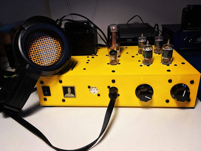 Bottlehead Stat Electrostatic Headphone Energizer in a yellow paint scheme with a pair of electrostatic headphones.